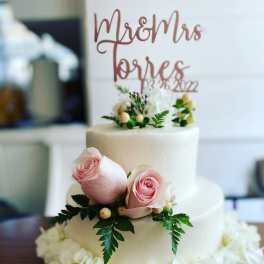 Two-tier white cake with pink roses and white flowers