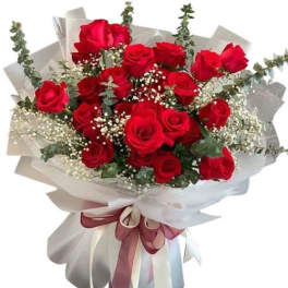 Bouquet of red roses wrapped in white paper with a ribbon