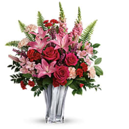 Bouquet of pink lilies, roses, and carnations in a clear glass vase