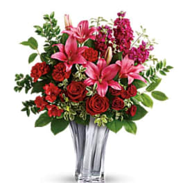Pink lilies and red roses in a clear glass vase