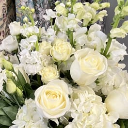 White roses and hydrangeas with pale green stock in a bouquet