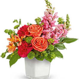 Mixed bouquet of roses, alstroemeria, and snapdragons in a white vase