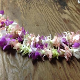 A pastel flower lei made of purple, pink, and white blossoms.