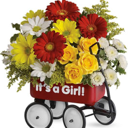 Bouquet of red, yellow, and white flowers in a red wagon