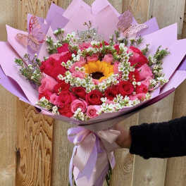 Pink and red rose bouquet with a sunflower center and butterfly decorations