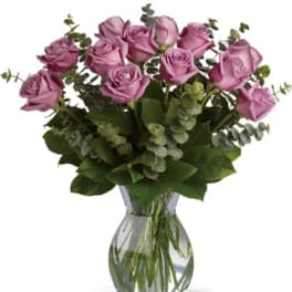 Lavender roses arranged in a clear glass vase