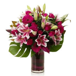 Pink lilies and gerbera daisies in a glass vase