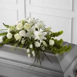 White floral casket spray with lilies and roses