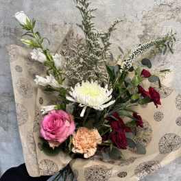 Bouquet of roses, chrysanthemum, and carnations wrapped in patterned paper