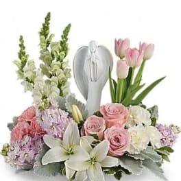 Pink roses and white lilies arranged around a silver angel keepsake