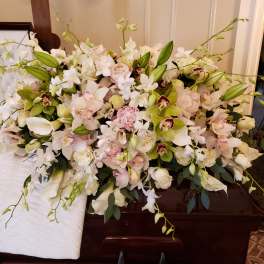 Large white and blush floral casket spray with orchids and roses