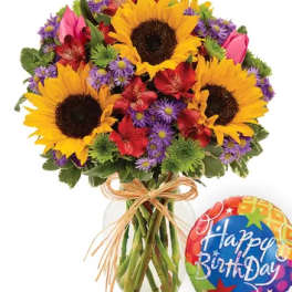 Bouquet of sunflowers, red flowers, and purple daisies in a glass vase with a birthday balloon