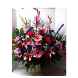 Large mixed bouquet of pink, red, and purple flowers in a vase