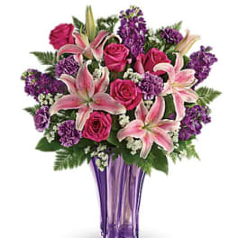 Pink roses and lilies arranged in a purple vase