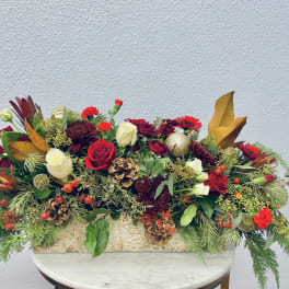 Long holiday centerpiece with red and white roses in a wooden box