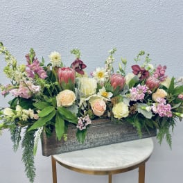 Mixed floral arrangement in a rectangular metal planter