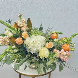 Mixed floral arrangement with peach roses and white hydrangea in a vase