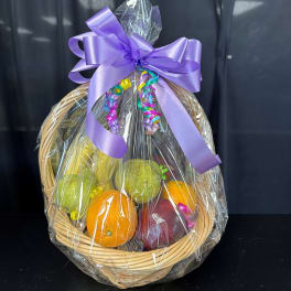 Fruit basket with oranges, pears, and an apple wrapped in clear cellophane