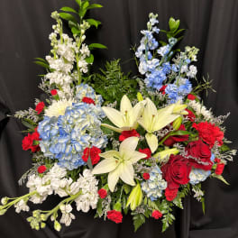 Mixed bouquet with white lilies, blue hydrangeas, red roses, and white stock