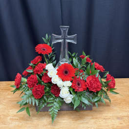 Red and white floral arrangement with a clear glass cross centerpiece