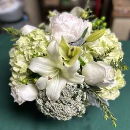 White floral bouquet with lilies, roses, and pale hydrangeas