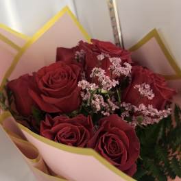 Bouquet of red roses with pink filler flowers in pink wrapping