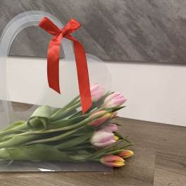 Pink and orange tulips in a clear gift sleeve with a red ribbon