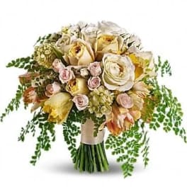 Bouquet of cream and pale pink roses with trailing greenery