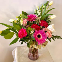 Pink and white mixed flower arrangement in a glass vase