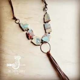 Beaded necklace with irregular stone-like pendants and a tassel