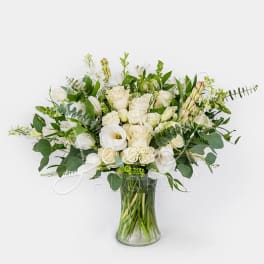 White roses and calla lilies in a clear glass vase