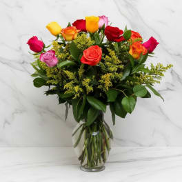 Mixed roses in a clear glass vase with yellow filler flowers