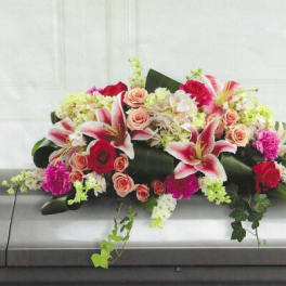Casket spray with pink lilies, roses, and hydrangeas
