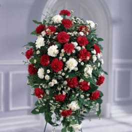 Standing spray of red and white carnations on a metal easel