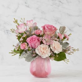 Pink roses and carnations in a pink glass vase