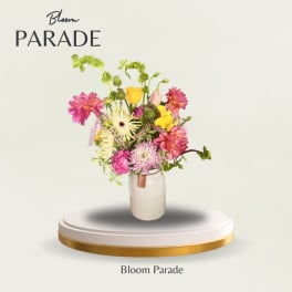 Mixed bouquet of pink, yellow, and white flowers in a glass vase