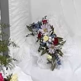 White floral bouquet with red and blue accents on white fabric