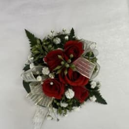 Red rose corsage with white baby's breath and ribbon on a white background