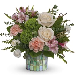 Pink and cream flowers in a mosaic glass vase