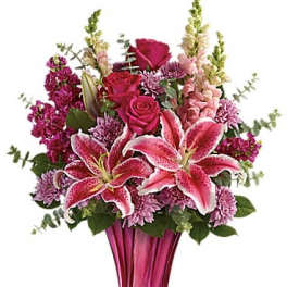 Pink lilies and roses in a tall magenta vase