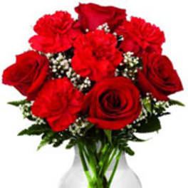 Red roses and carnations in a clear glass vase