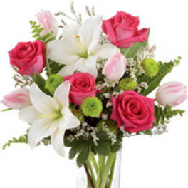 Pink roses and white lilies in a clear glass vase