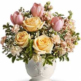 Pink tulips and yellow roses arranged in a white vase