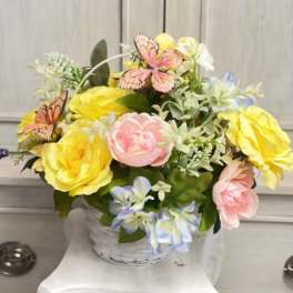 Basket of pastel flowers with butterfly accents