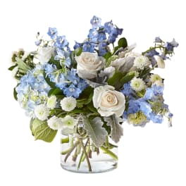 Blue and white bouquet with roses in a clear glass vase