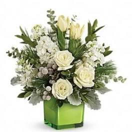 White roses and pale tulips arranged in a green square vase
