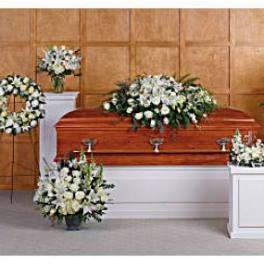 White funeral flowers arranged around a casket