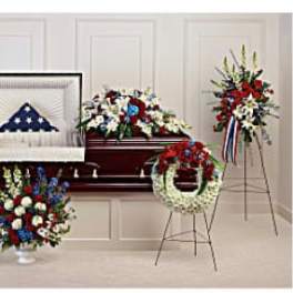Funeral casket spray and standing wreaths in red, white, and blue