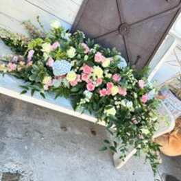 Pastel floral casket spray with pink, white, and blue blooms