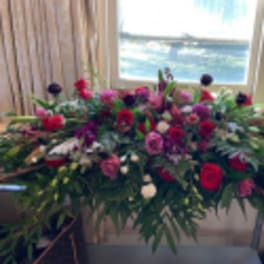 Large floral casket spray with red, pink, and white blooms